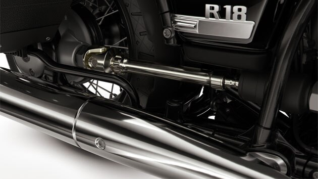 We see the round exhaust pipe, the open drive shaft, and the double cradle frame.