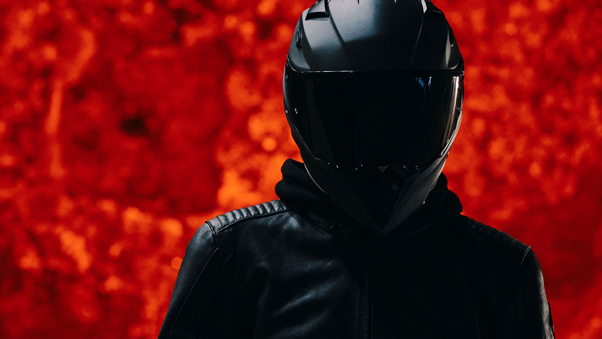 We see a darkly dressed person standing in front of a red-hot steel boiler.